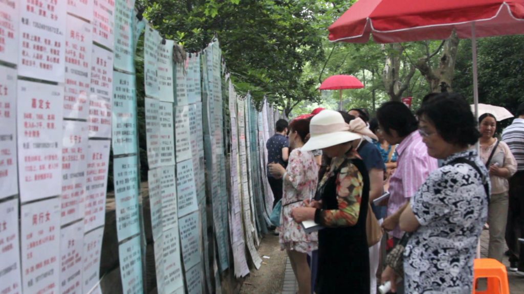Parents reading signs advertising for dates in the People's Park in Shanghai, China